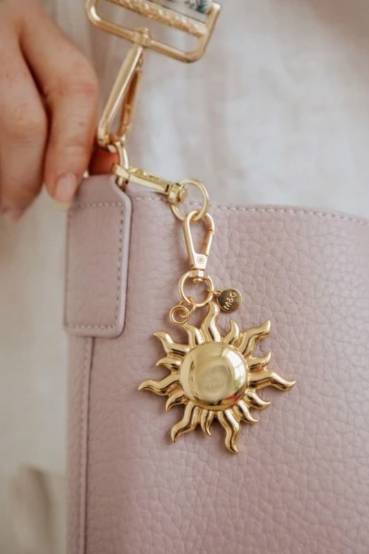 Modern + Chic See the Light Charm – Bag Charm for Purses hooked to the strap of a light purple Modern + Chic bag.