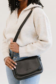 A woman wearing a black crossbody bag.