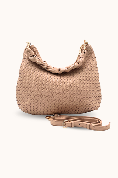 A dusty blush Modern+Chic Kelly Woven Convertible Crossbody Shoulder Bag with included vegan leather adjustable crossbody strap on a white background. 