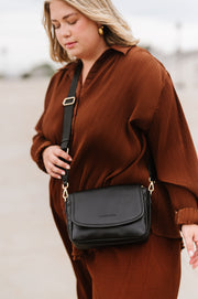 A woman wearing a black crossbody bag.