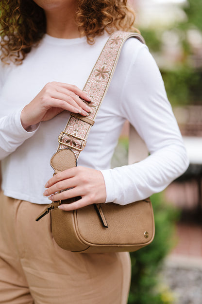 Woman wearing white shirt, tan pants and a Modern + Chic Gentry Vegan Leather Crossbody Bag in camel. 