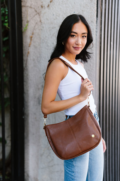 A woman wearing a brown
Marissa Vegan Leather Saddle Crossbody Bag | Modern + Chic handbag on her shoulder. 