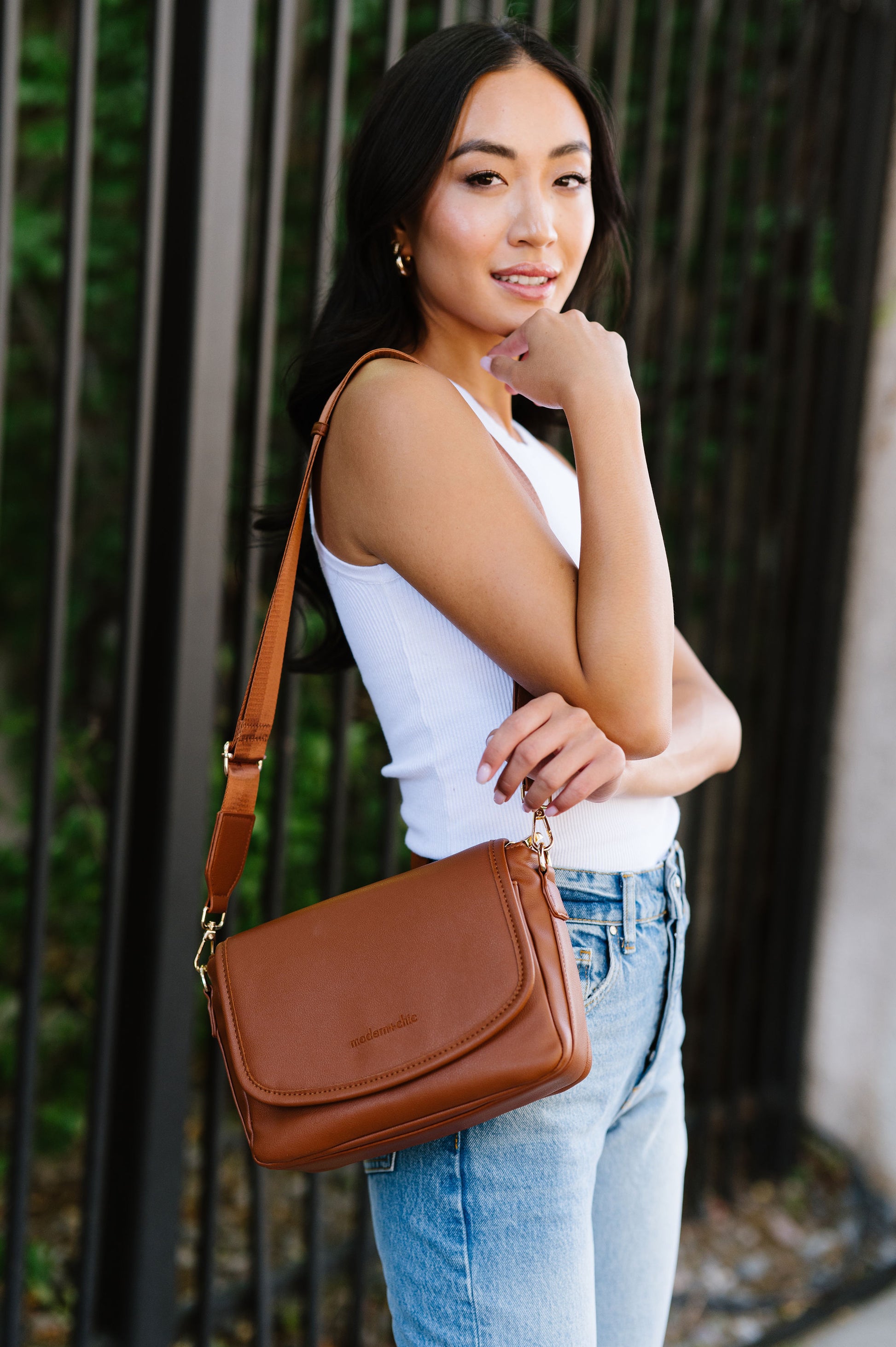 A woman wearing a brown crossbody.