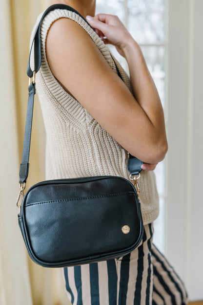 A woman wearing a black shoulder bag.
