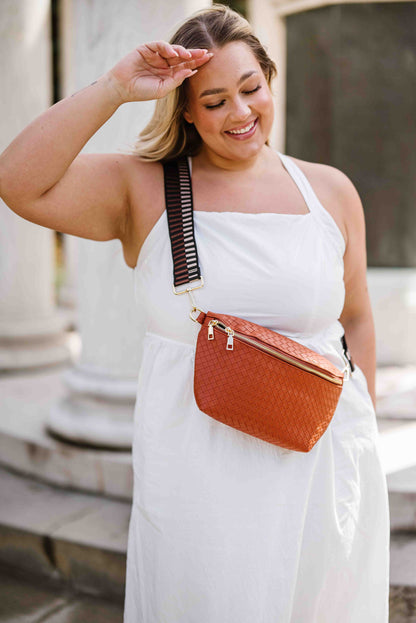 Woman wearing a white sundress wearing a copper faux quilted Modern + Chic Rory Oversized Belt Bag for Women with a gold zipper and hardware crossbody.